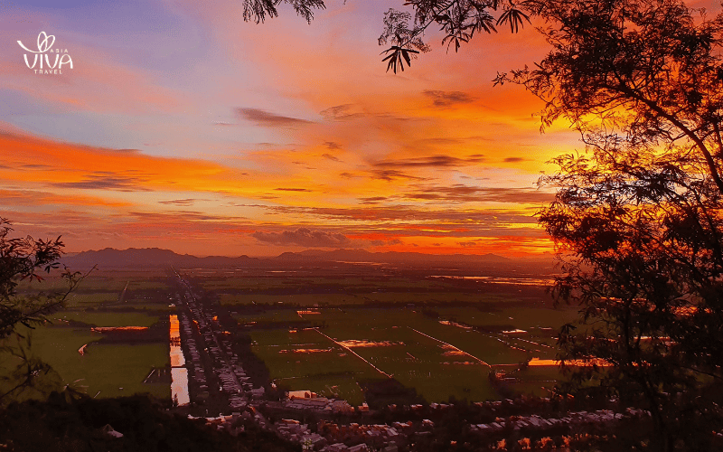 Sunset from the peak of Sam Mountain, casting a golden glow over Chau Doc’s vast rice fields