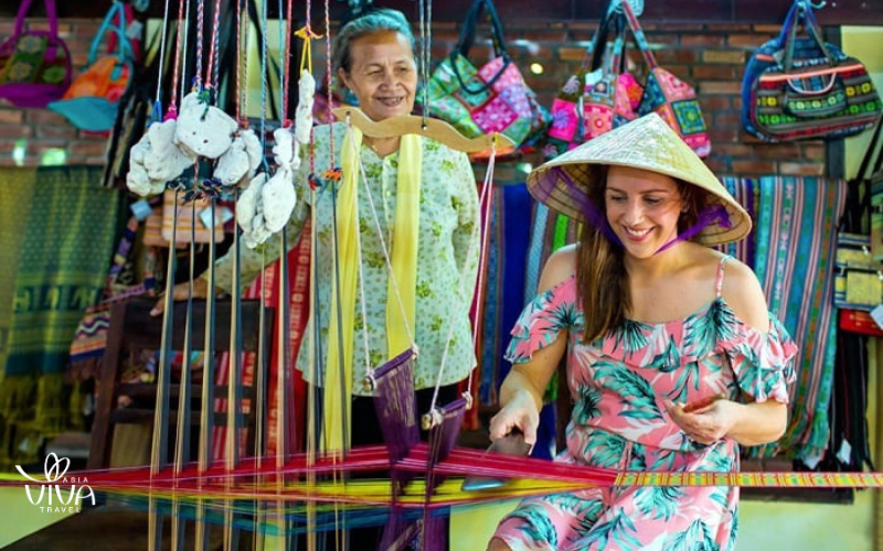 I visitatori sperimentano la tessitura della seta al museo di Hoi An