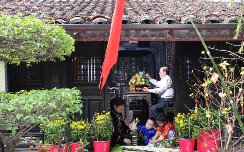 La famille est animée et excitée de préparer du banh chung et des plateaux de cinq fruits pour le Têt
