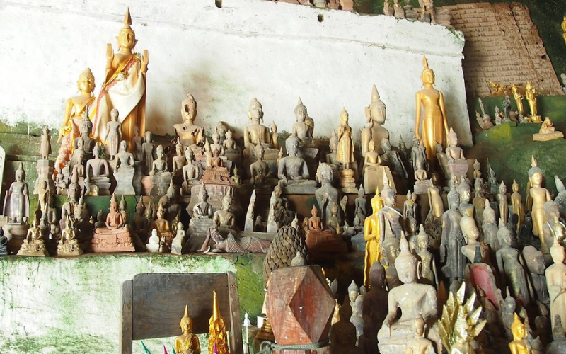 Beaucoup des statues de tailles variées et fabriquées à partir de différents matériaux dans la grotte de Pak Ou