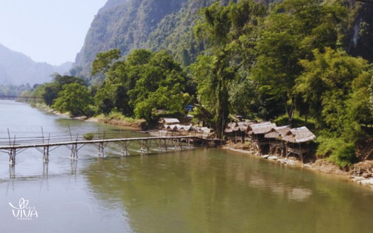 The serene Nam Song River with majestic limestone karsts forms the stunning backdrop of Vang Vieng